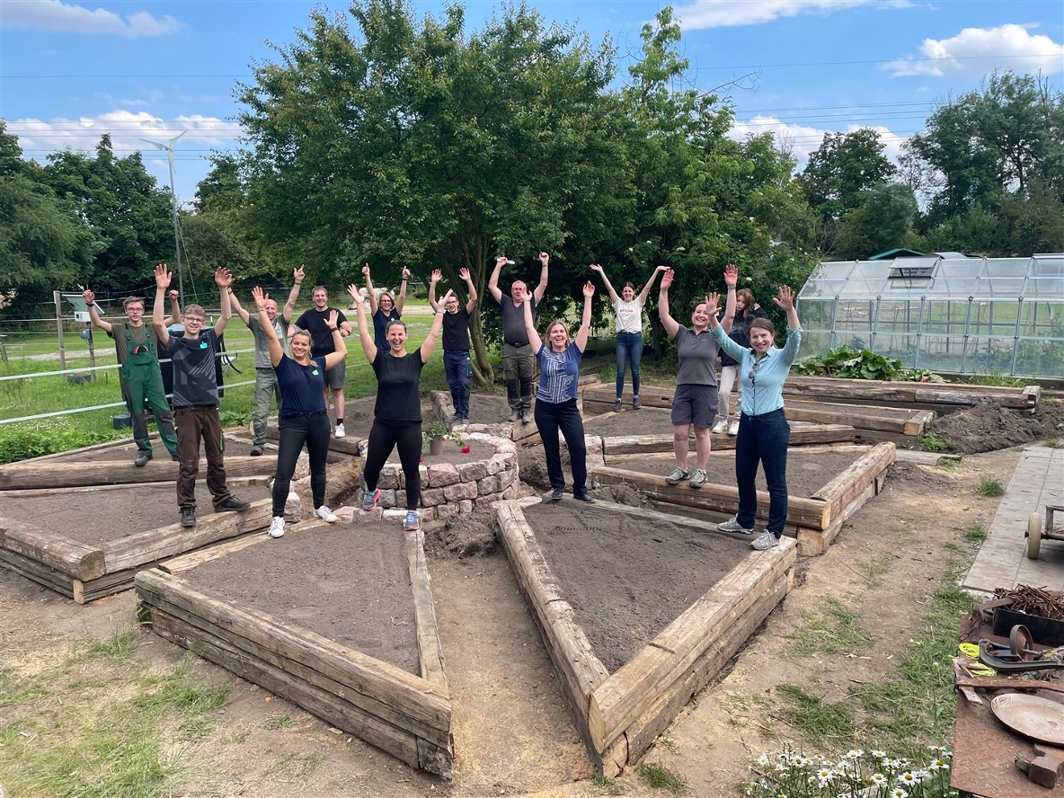 Mitarbeitende der BayWa AG engagieren sich sozial und präsentieren voller Stolz den fertig erbauten Gemüsegarten auf dem GENERATIONENHOF Leipzig