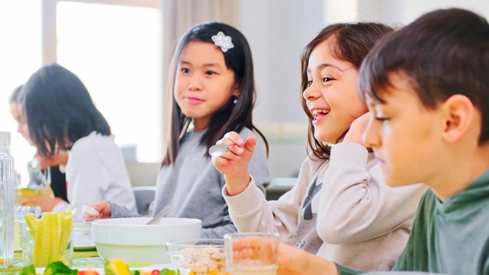 Kinder beim Frühstücken am Tisch